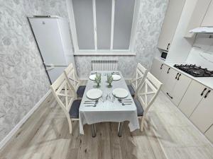 a dining room with a table and chairs in a kitchen at Mars APARTMENTS KZ 97 in Aktobe