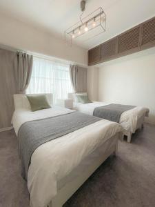 1 Schlafzimmer mit 2 Betten und einem Kronleuchter in der Unterkunft Accommodates up to 11 guests!!Staypia Condominium Namba Ebisu in Osaka