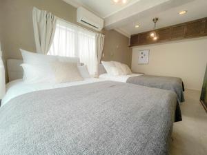 1 Schlafzimmer mit 2 Betten und einem Fenster in der Unterkunft Accommodates up to 11 guests!!Staypia Condominium Namba Ebisu in Osaka
