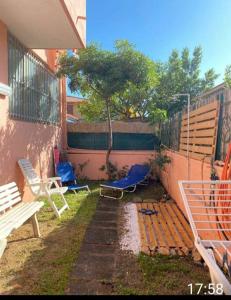 un patio trasero con sillas, una valla y un banco en Casa rossa, en Solanas