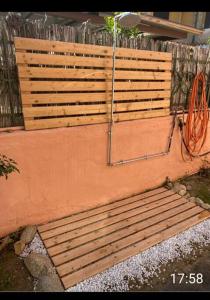 un banco de madera sentado en un lateral de una pared en Casa rossa, en Solanas