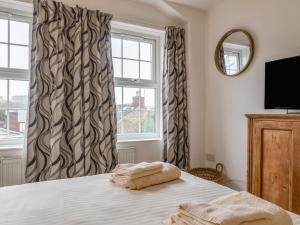 ein Schlafzimmer mit einem Bett und einem Fenster in der Unterkunft Bumblebee Cottage in Salcombe