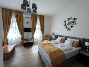 ein Schlafzimmer mit einem großen Bett und ein Wohnzimmer in der Unterkunft Kúria Vendégház in Poroszló