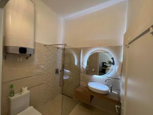 a bathroom with a toilet and a sink and a shower at Kúria Vendégház in Poroszló