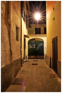 an alley with a green door with graffiti on it at B&B Au Caruggiu in Ceriale