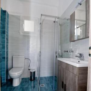 a bathroom with a toilet and a sink and a shower at GERANI apartments in Órmos