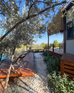 een houten terras met een bank naast een huis bij Lovin Göcek Tiny House Butterfly in Gökçeovacık