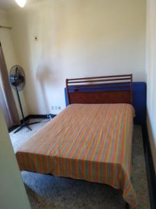 a bedroom with a bed with a striped bedspread at Apartamento charmoso in Saquarema