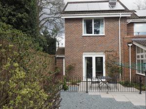 a brick house with a black fence and a patio at Brundall House in Norwich