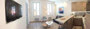 a kitchen with a large television and a living room at Au Coeur de Cassis in Cassis