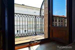 una puerta abierta a un balcón con vistas a un edificio en Apartamento Llerandi 2B - Totalmente reformado y con balcón al corazón de San Vicente de la Barquera, en San Vicente de la Barquera