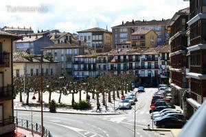 una calle de la ciudad con coches y edificios aparcados en Apartamento Llerandi 2B - Totalmente reformado y con balcón al corazón de San Vicente de la Barquera, en San Vicente de la Barquera