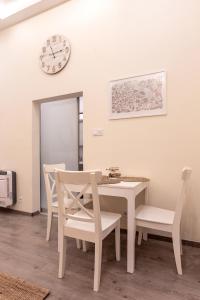 une salle à manger avec une table, des chaises et une horloge dans l'établissement Goldcentral Apartment Comfort, à Budapest