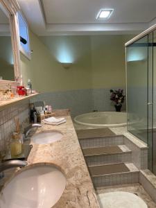 bagno con 2 lavandini, doccia e vasca di Casa 32 Angra - Itanema - Angra dos Reis ad Angra dos Reis