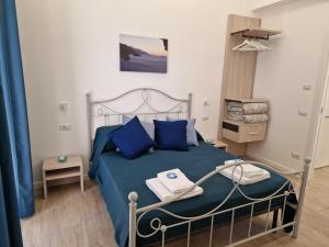 a bedroom with a blue bed with blue pillows at Siren Land - Marina del Cantone in Nerano