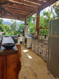 une grande cuisine avec un comptoir et un réfrigérateur dans l'établissement Secret View Suítes, à Ubatuba