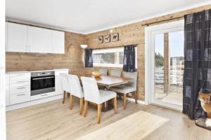 a kitchen and dining room with a table and chairs at Vacation apartment in Hornnes