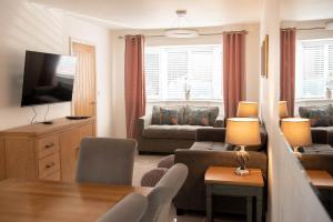 a living room with a couch and a tv at RiverTree House in Llangollen