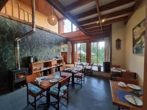 a dining room with tables and chairs and a fireplace at Hostel Torobayo in Valdivia