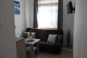 a living room with a couch and a table at Apartament "u Mamy" Władysławowo in Władysławowo