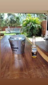 a bottle of beer and a bucket on a table at Casa con Piscina y Parrilla in Garupá