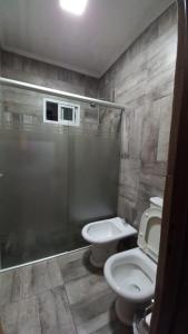 a bathroom with a toilet and a sink and a shower at Casa con Piscina y Parrilla in Garupá