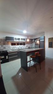 a kitchen with a counter and some chairs in it at Casa con Piscina y Parrilla in Garupá