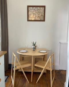 Dundrum的住宿－Buttercup Cottage，餐桌、两把椅子和一张带酒杯的桌子