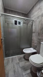 a bathroom with a shower and a toilet and a sink at Casa con Piscina y Parrilla in Garupá