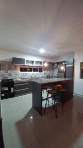 a kitchen with a counter and some chairs in it at Casa con Piscina y Parrilla in Garupá