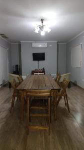 comedor con mesa de madera y sillas en Casa con Piscina y Parrilla en Garupá