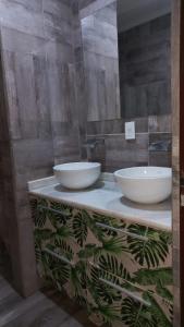 un baño con dos tazones blancos en una encimera en Casa con Piscina y Parrilla en Garupá