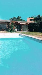 una gran piscina de agua azul frente a una casa en Casa con Piscina y Parrilla en Garupá