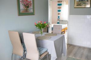 Studio Luna Appartement في كارلوفاتش: طاولة غرفة الطعام مع إناء من الزهور عليها