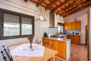 a kitchen with a wooden table and a dining room at Casa con piscina cerca de Girona in Girona
