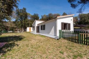 una casa blanca con una valla en un patio en Casa con piscina cerca de Girona en Girona