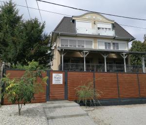 a house with a sign on a fence at Villa Pelso in Balatongyörök