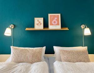 a bedroom with two beds and two lights on a blue wall at Kajüthus Apartment 6 in Fehmarn