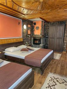 a bedroom with two beds and a fireplace at Guest rooms Colorit in Koprivshtitsa