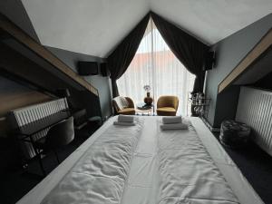 a large bed in a room with a large window at Hotel Oostereiland in Hoorn