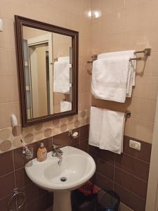 W łazience znajduje się umywalka, lustro i ręczniki. w obiekcie Home Sweet Rental w Tiranie