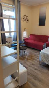 ein Wohnzimmer mit einem roten Sofa und einem Tisch in der Unterkunft Glam Resort G H O S T E L in La Spezia