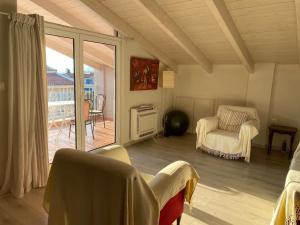 ein Wohnzimmer mit einem Tisch und einem Stuhl sowie einem Balkon in der Unterkunft Sunny apartment with mountain view in Patras