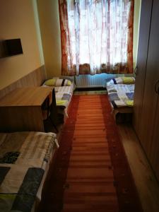 Moldava nad BodvouにあるHostel SOS Moldavaのベッド3台と窓が備わる客室です。