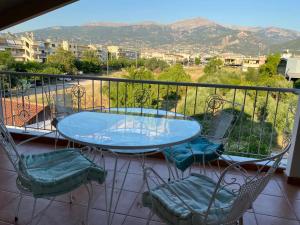 einen Tisch und Stühle auf einem Balkon mit Bergblick in der Unterkunft Sunny apartment with mountain view in Patras