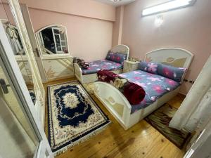 Habitación con 2 camas y espejo. en شقة خلف شارع طرح البحر عند عبده كفته307, en Puerto Saíd