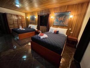a bedroom with two beds with towels on them at TucanTico Lodge ~ Casa # 3 in Monteverde Costa Rica