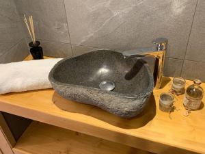 a stone sink on top of a wooden counter at Chalet****Luxe Sauna & SPA Le Champenois in Samoëns