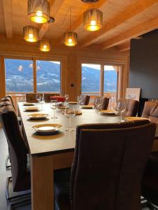 a large table with chairs and wine glasses on it at Chalet****Luxe Sauna & SPA Le Champenois in Samoëns