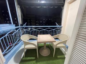 un tavolo e 2 sedie sul balcone di شقة خلف شارع طرح البحر عند عبده كفته307 a Port Said